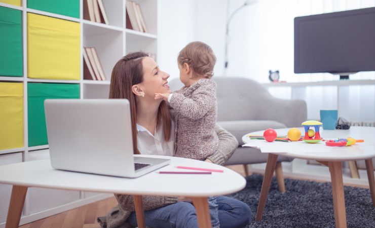 mamma che lavoro con figlio in braccio