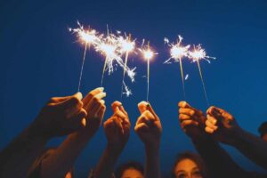 persone con stelline di capodanno in mano