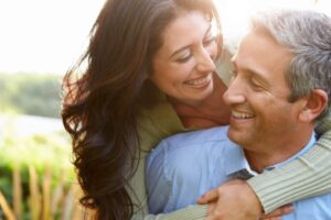 donna che sorride e abbraccia un uomo da dietro