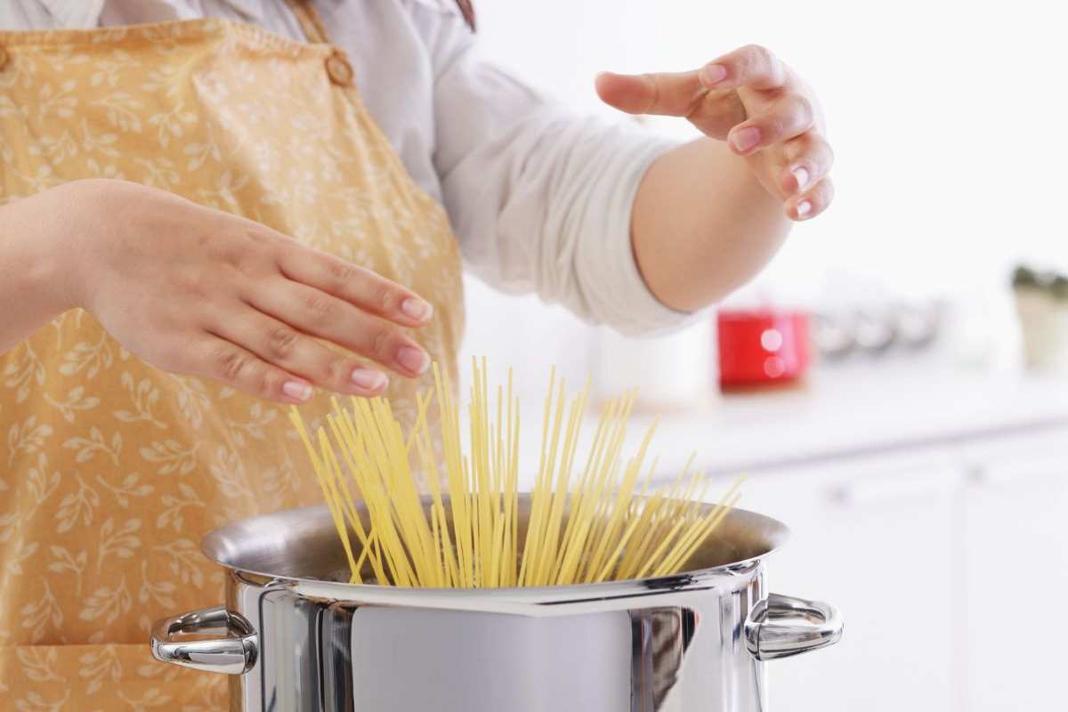 donna ha appena gettato gli spaghetti nell'acqua bollente