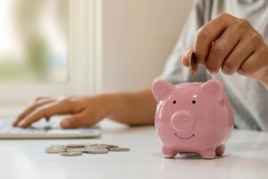 persona che mette monete nel salvadanaio