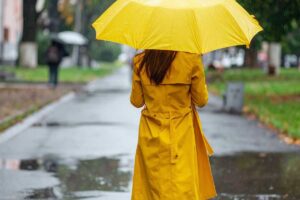donna al parco di spalle con un ombrello