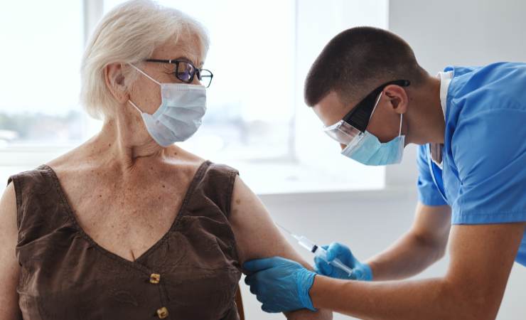 medico che fa vaccino ad anziana