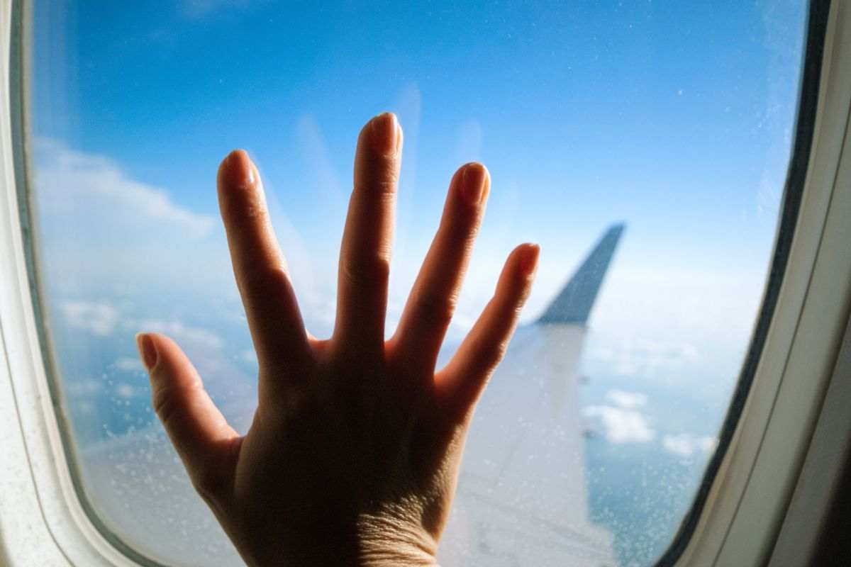 mano sul finestrino dell'aereo