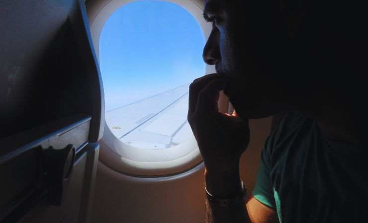 persona in aereo che ha paura e si mangia le unghie