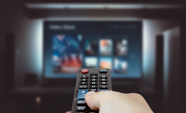 mano con telecomando e tv