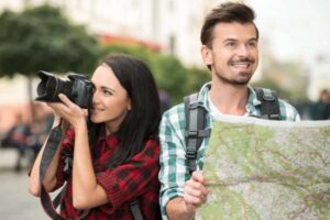 donna con la macchina fotografica e uomo con una cartina geografica