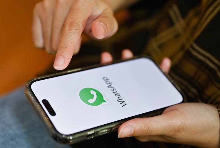 smartphone in mano con logo whatsapp