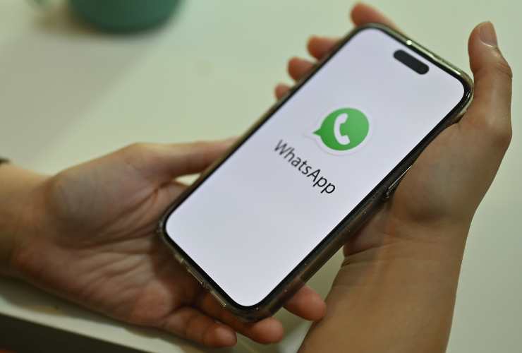 smartphone in mano con logo whatsapp