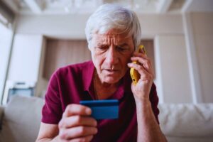 signore al telefono con una carta in mano
